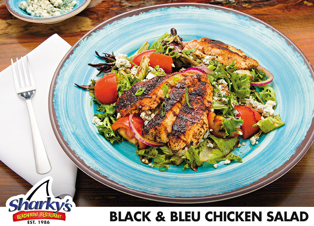Black & Bleu Chicken Salad is made with blackened chicken over sliced red onions, tomatoes, seasonal berries Bleu cheese crumbles & Arcadian mix tossed in Balsamic vinaigrette.