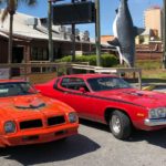 2 classic cars in front of Sharky's for Emerald Coast Cruizin'