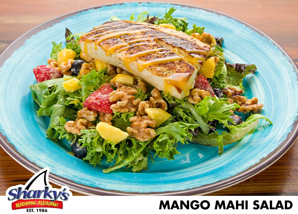 Mango Mahi Salad made with Grilled filet of Mahi Mahi with a Mango sauce over Arcadian Mix with diced mango, seasonal berries & walnuts all tossed in Pineapple vinaigrette